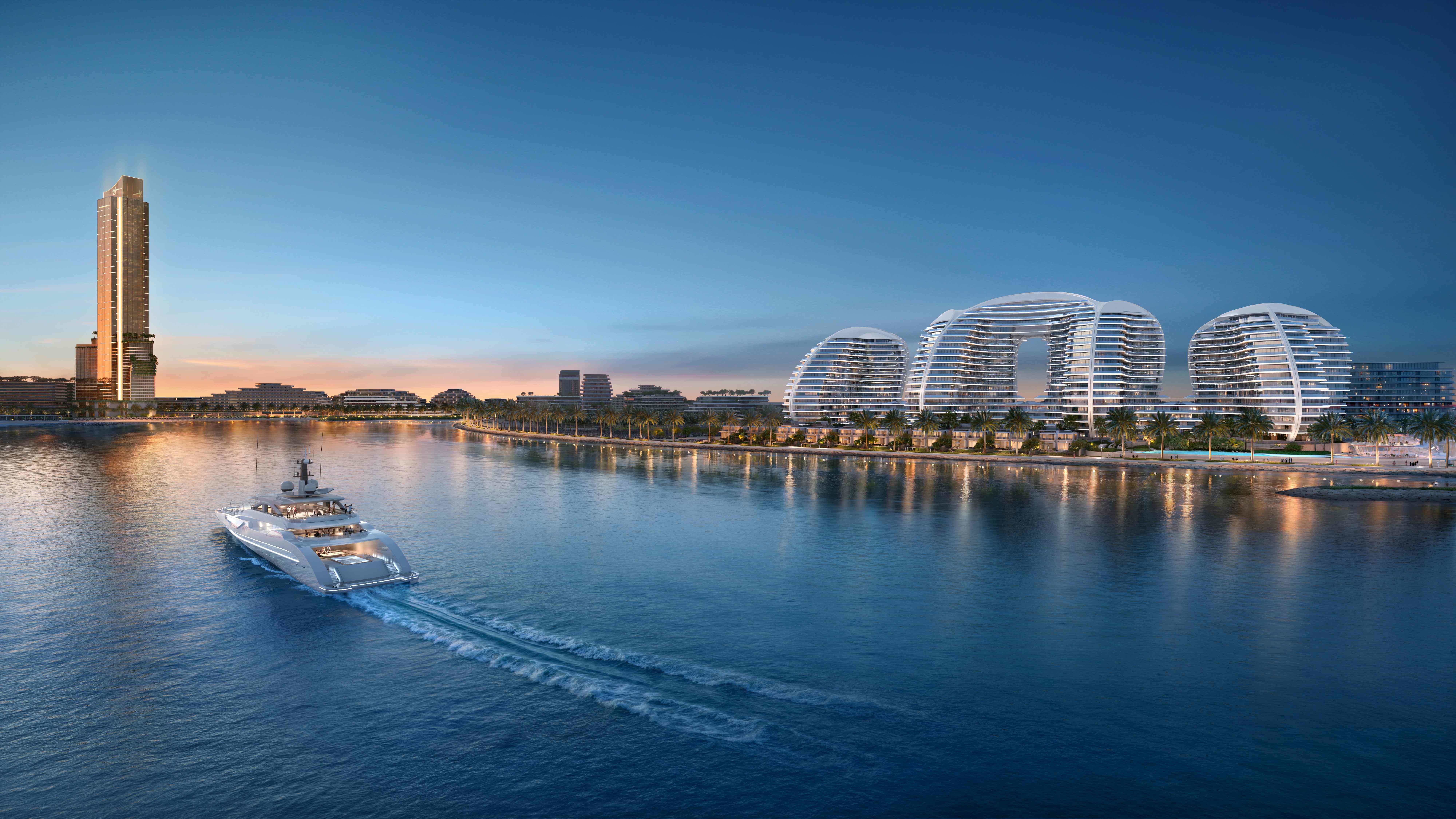 Wynn Al Marjan Island resort at golden hour sunset with luxury superyacht, illuminated promenade, and iconic tower reflecting in Arabian Gulf waters
